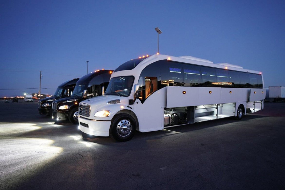 Super coach bus for wedding guest shuttle transportation, rear view at dusk