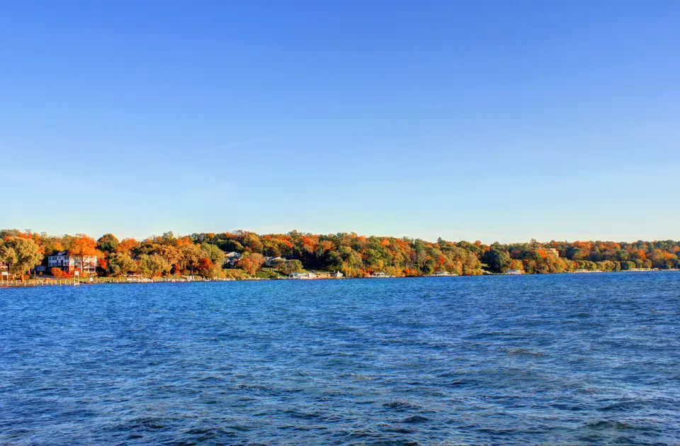 Autumn trees reflected across Geneva Lake in Wisconsin