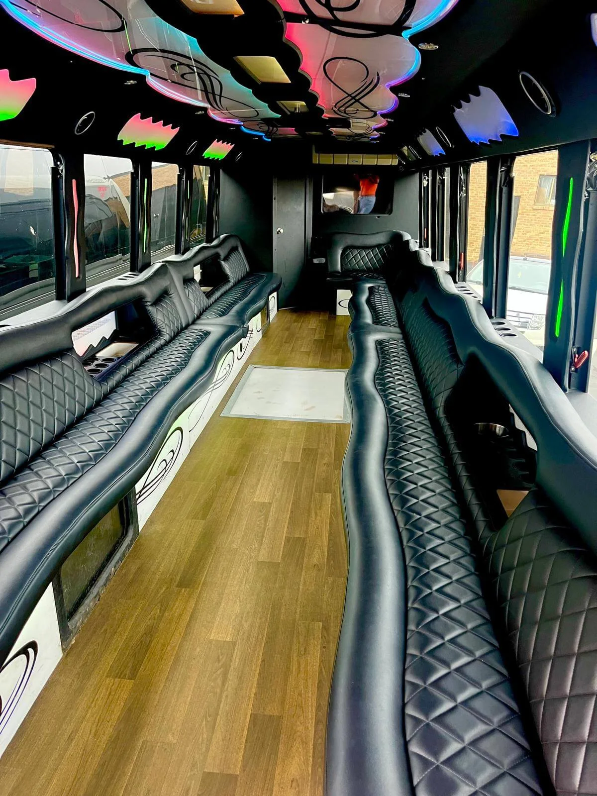 Lounge seating and colored lighting inside the party bus