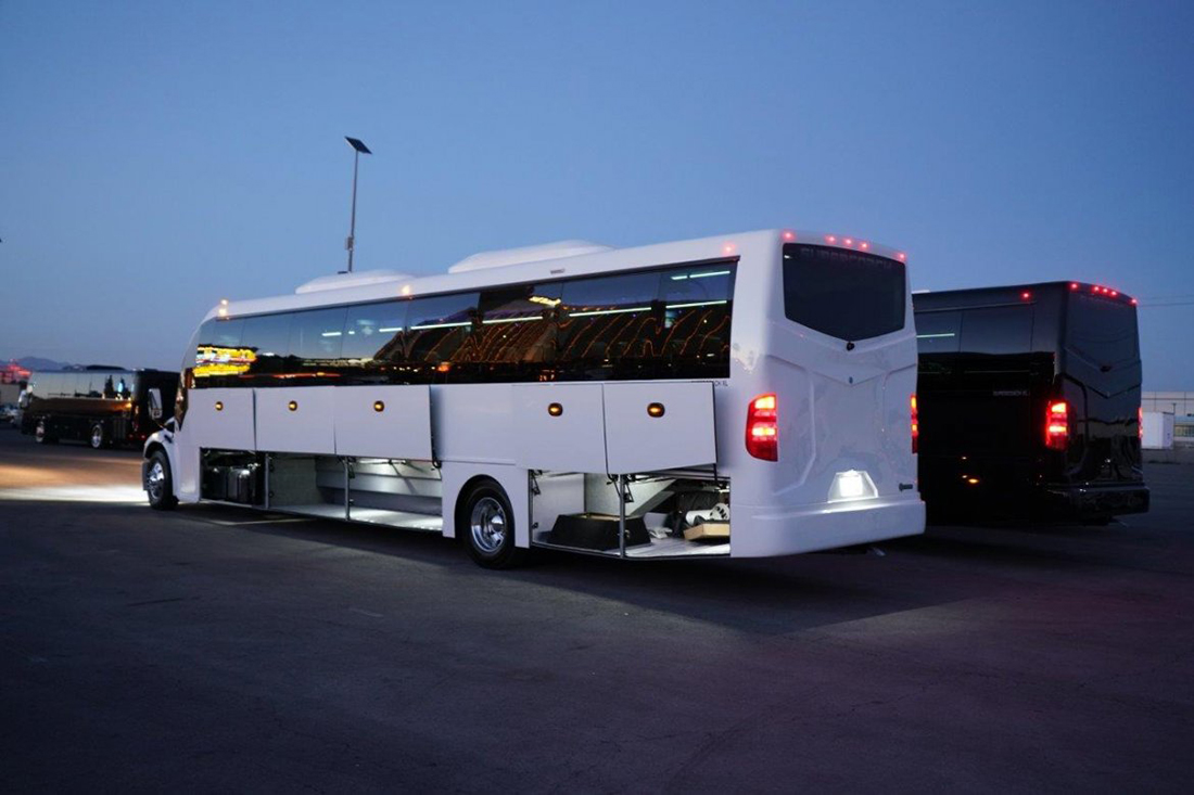 Coach buses staged at dusk for a wedding guest shuttle pickup